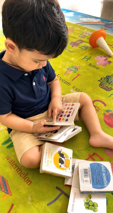 Child exploring books on a play mat